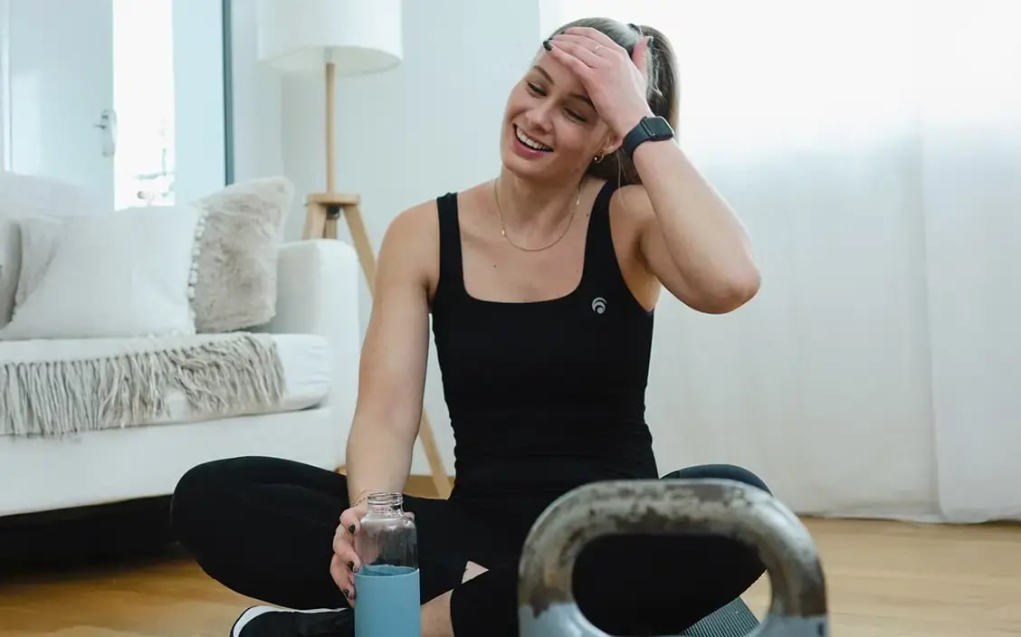 Frau wischt sich über die Stirn nach 45 Minuten Training