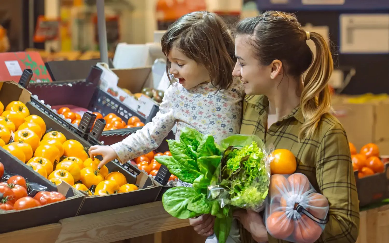 Fitte Mutter trägt Tochter bei Einkauf
